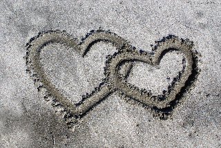 cuori che si toccano sulla spiaggia