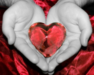 cuore di cristallo rosso nelle mani